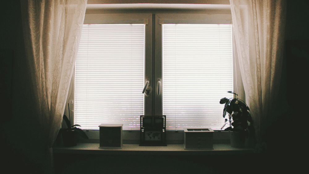 カーテン越しの光が差し込む静かな窓辺の室内で、メンタル不調を振り返る内省のイメージ画像